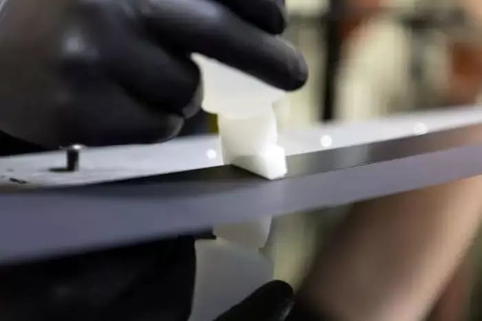 Product engineer applying an adhesive bonding primer to a glass panel