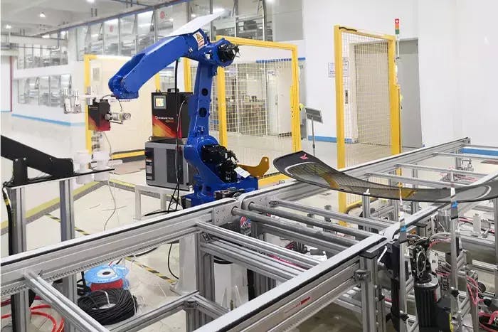 A Designetics e3 series fluid dispensing system integrated into a manufacturer's robotic arm